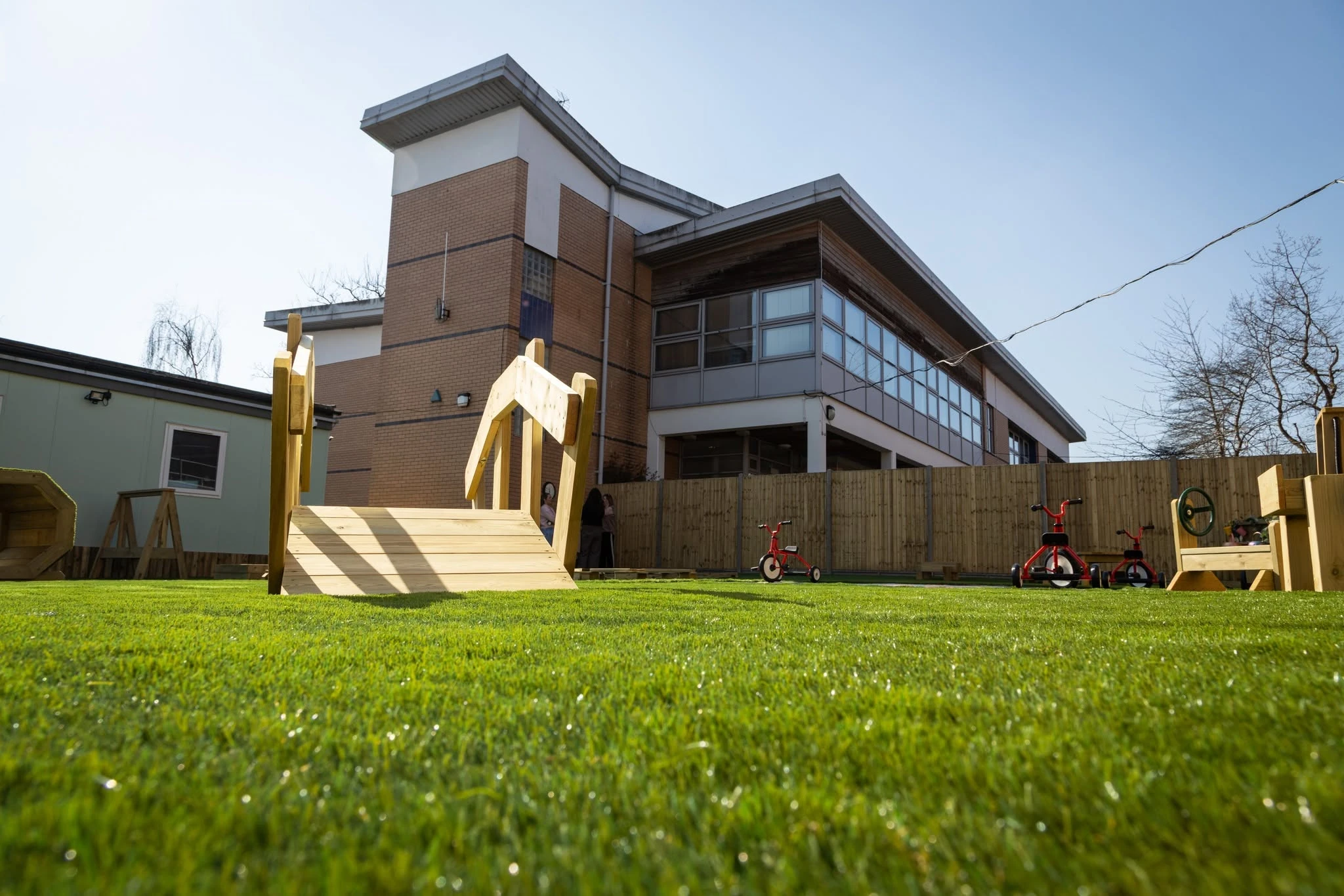 Nursery garden with timber play equipment and the Crouch End building beyond