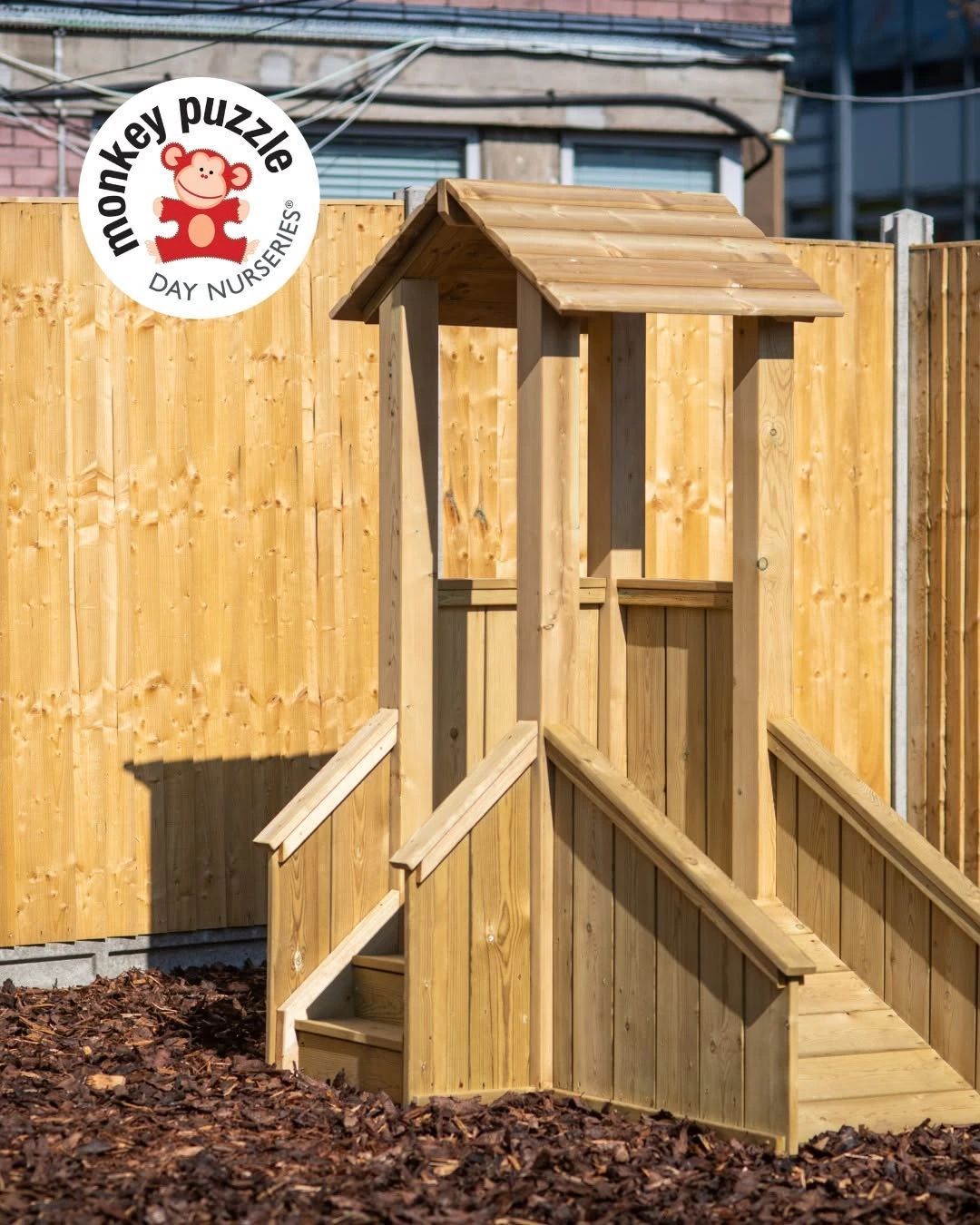 Timber play tower beside the garden fence
