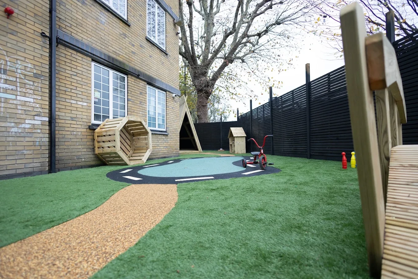 Nursery garden with artificial grass, a winding path and timber play shelters