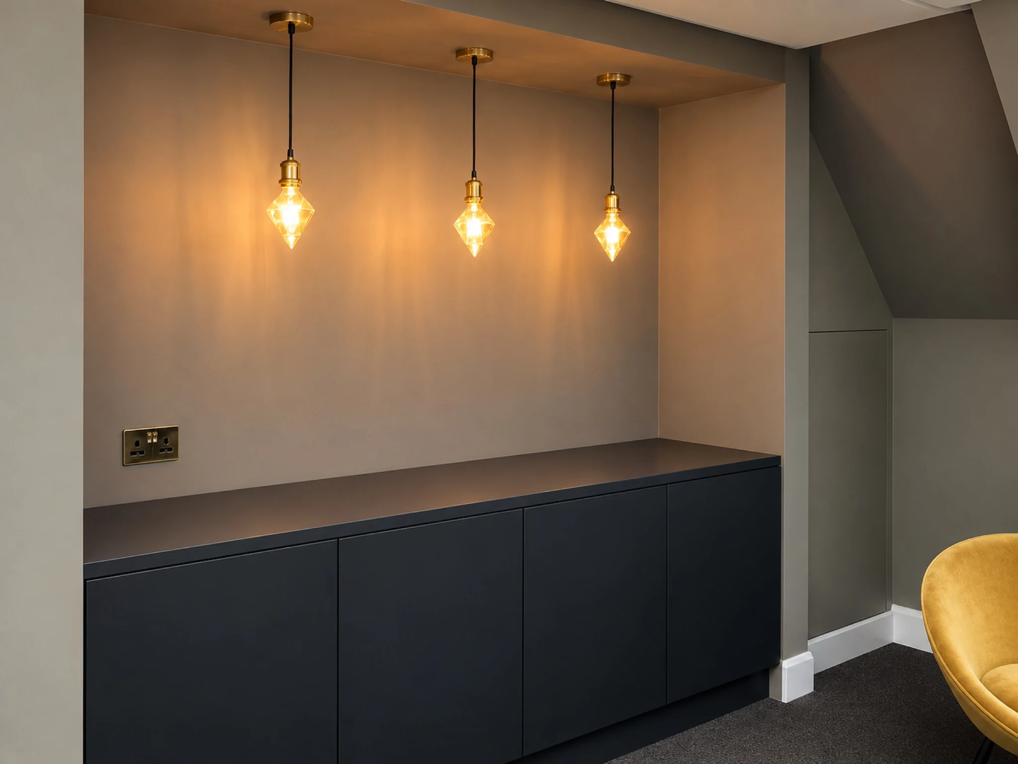 Pendant lighting above dark fitted cabinetry.