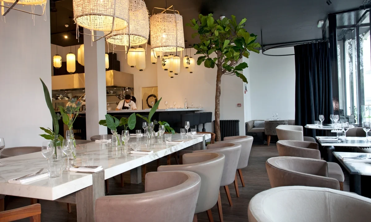 Marble dining tables, upholstered chairs and woven pendant lights at Angelina Dalston