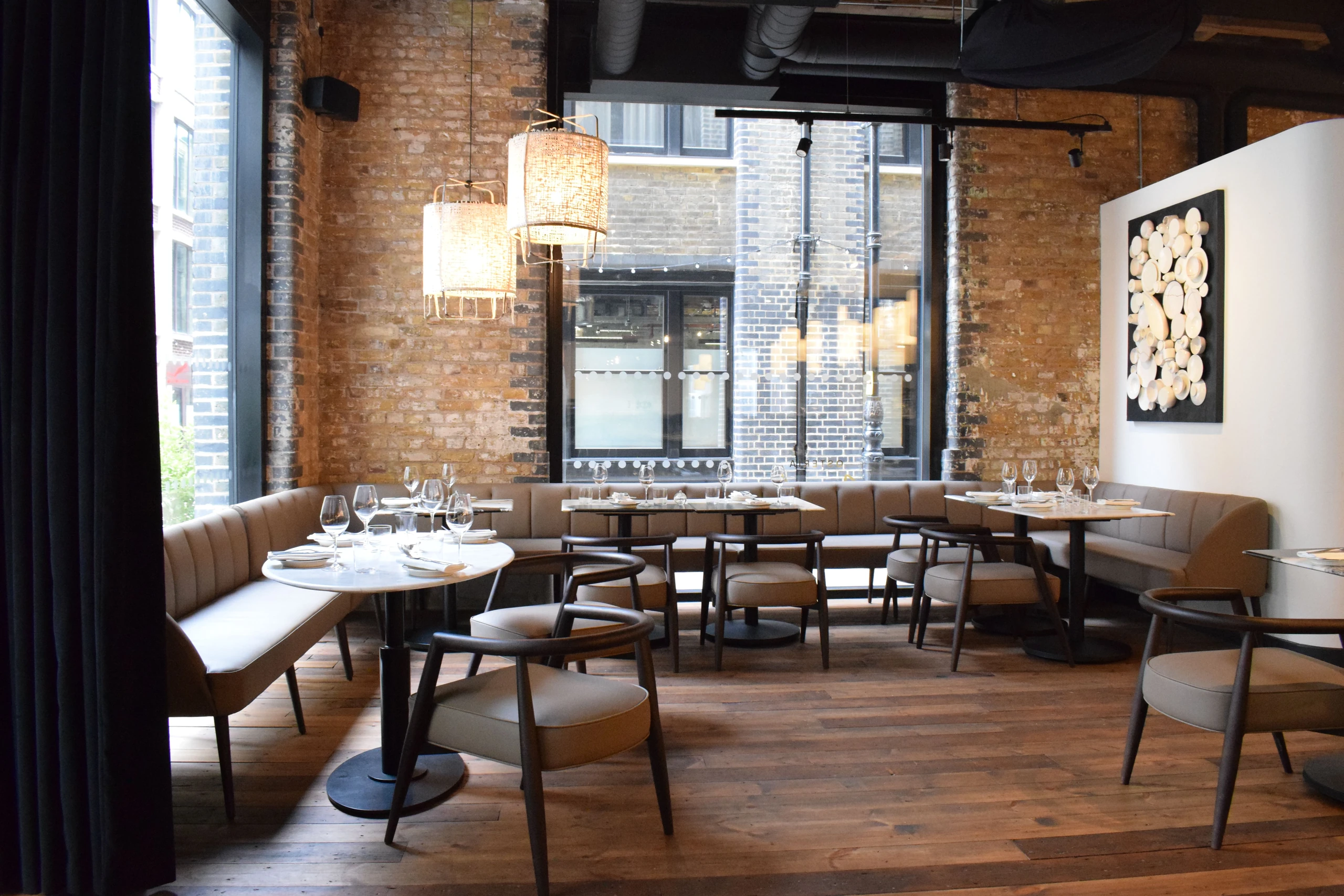 Exposed brick walls and dark timber furniture in the Osteria Angelina dining room